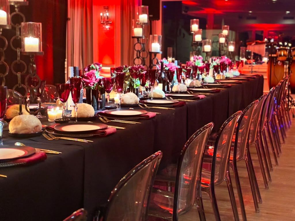 Hall with long dinner tables in deep red uplighting